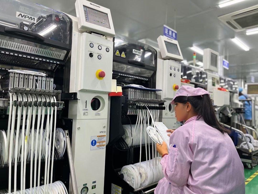 Quality inspector reviewing assembled PCB workmanship