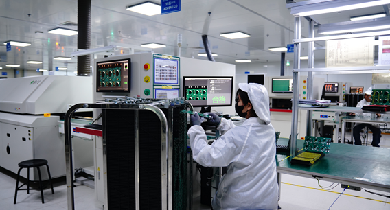 Operator handling circuit boards at an optical inspection station