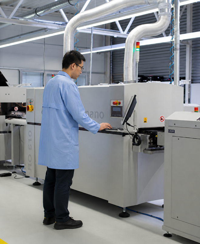Technician operating equipment on an electronics production line