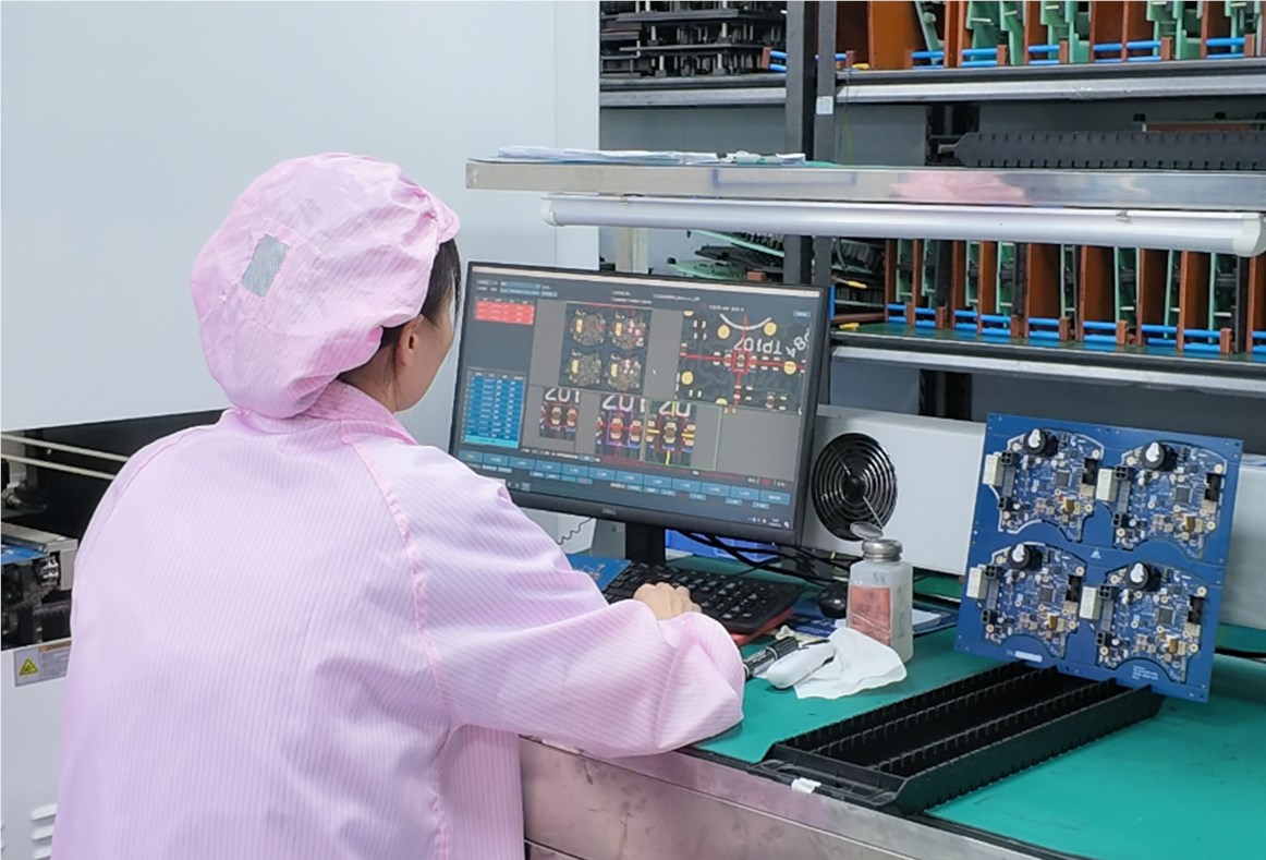 AOI operator reviewing assembled PCB inspection results at a workstation
