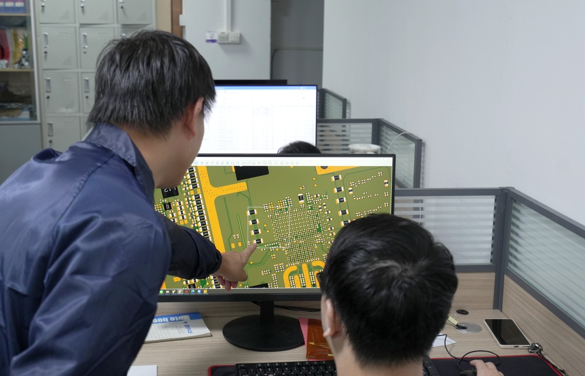 EBest PCBA engineer reviewing PCB layout details during DFM verification