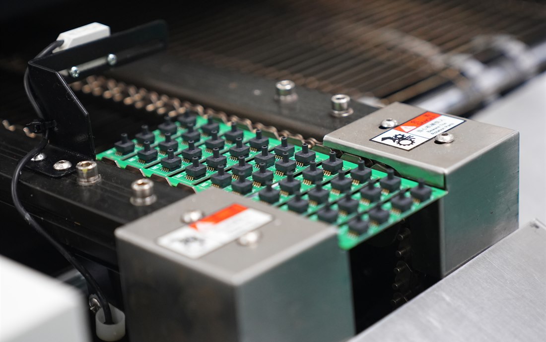 PCBA panels moving through an automated SMT production process